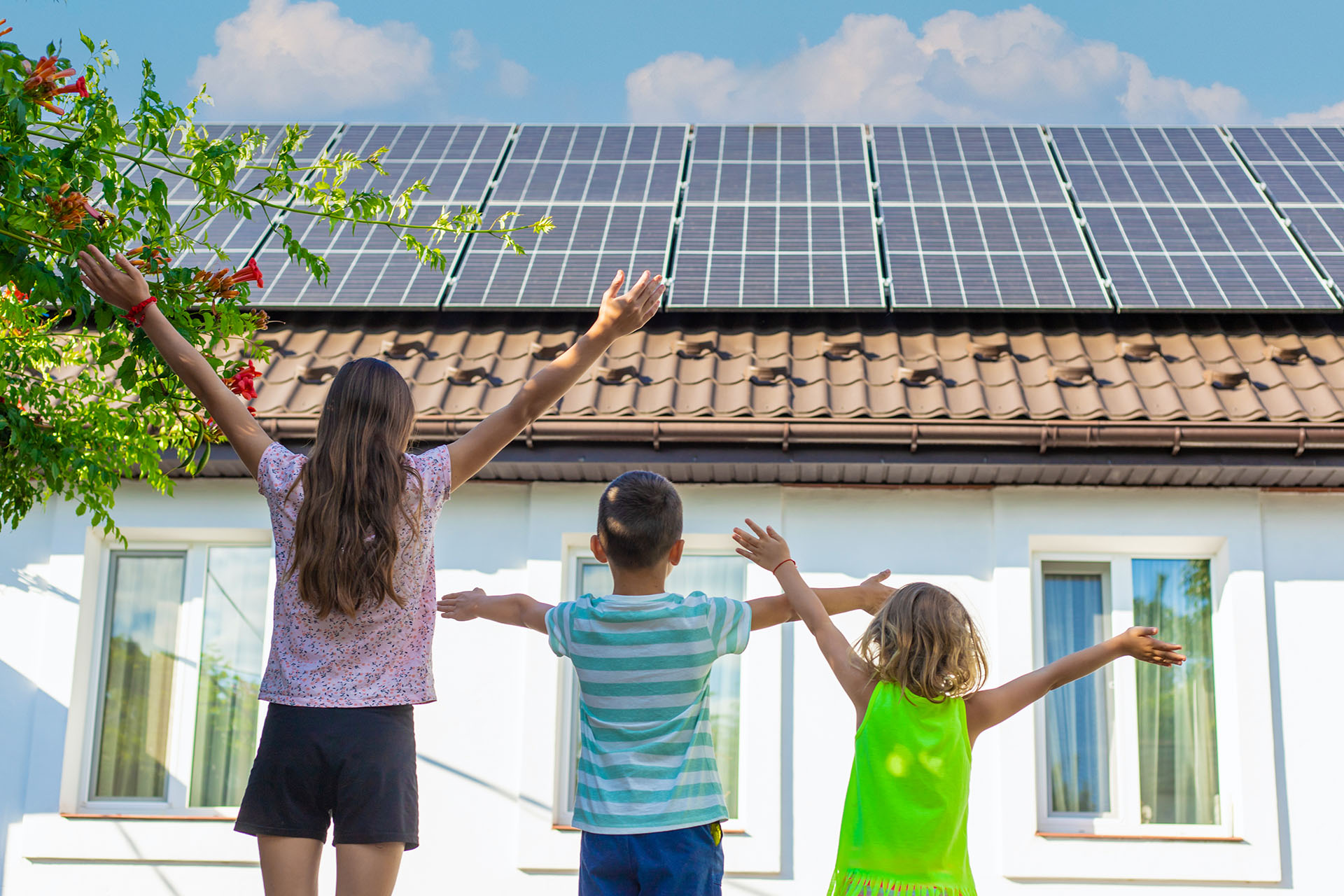 a-young-happy-family-is-standing-near-solar-panels